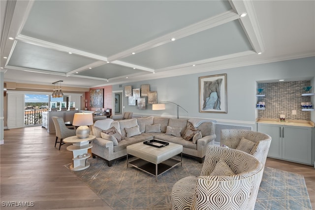 living room featuring coffered ceiling, wood-type flooring, and ornamental molding