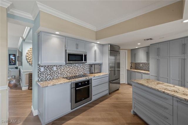 kitchen featuring light stone counters, gray cabinets, ornamental molding, and appliances with stainless steel finishes