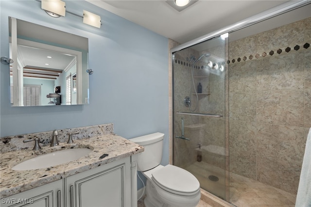 bathroom with vanity, toilet, and a shower with shower door