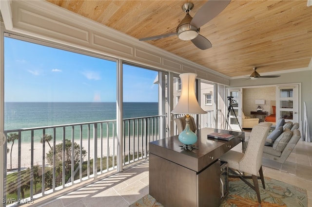 sunroom featuring ceiling fan, wood ceiling, a beach view, and a water view