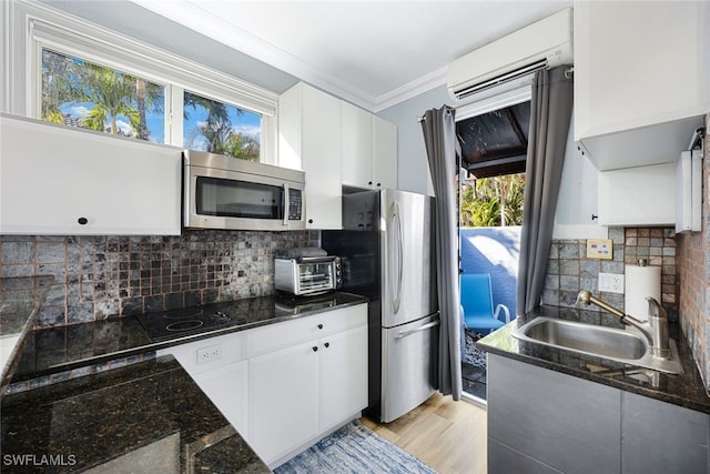 646 111th Ave N, Naples, FL 34108 - kitchen with stainless steel appliances, a wall mounted air conditioner, white cabinetry, tasteful backsplash, and ornamental molding