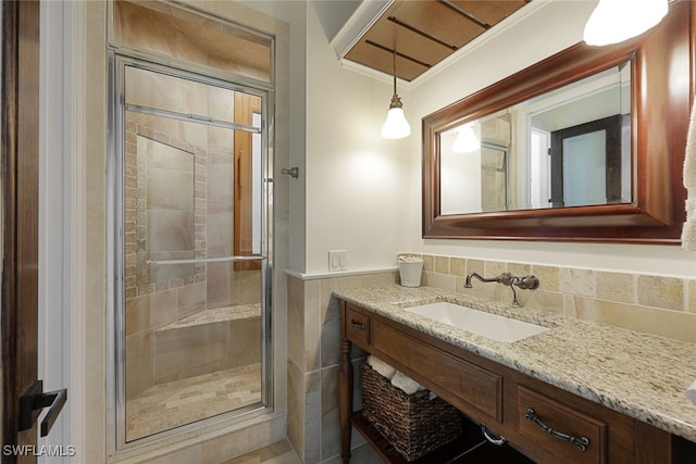 646 111th Ave N, Naples, FL 34108 - bathroom with a stall shower, vanity, a wainscoted wall, and tile walls
