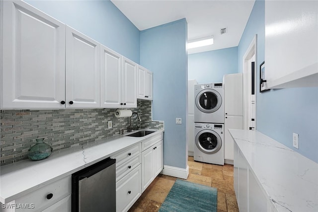 646 111th Ave N, Naples, FL 34108 - laundry area featuring stacked washer / drying machine and stone tile floors