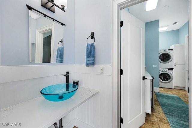 646 111th Ave N, Naples, FL 34108 - bathroom with stacked washer / drying machine, a wainscoted wall, and vanity