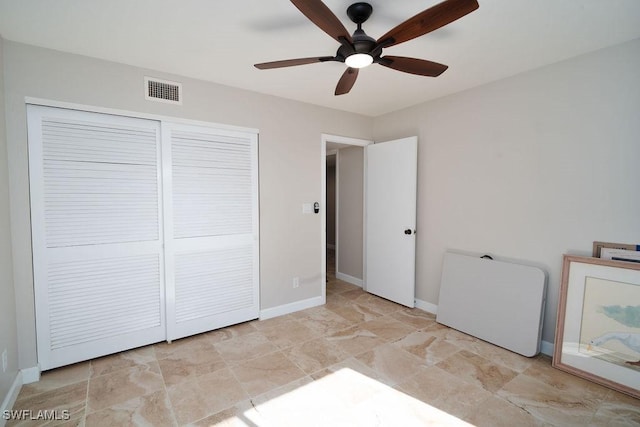 unfurnished bedroom with ceiling fan and a closet