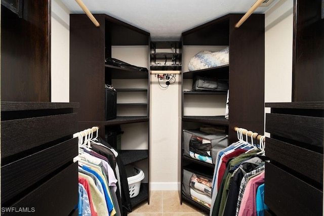 walk in closet with light tile patterned floors