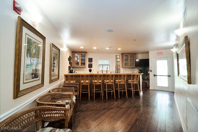 bar with a healthy amount of sunlight and dark hardwood / wood-style flooring