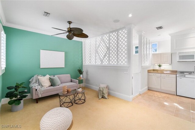 living area with visible vents, crown molding, light carpet, and baseboards