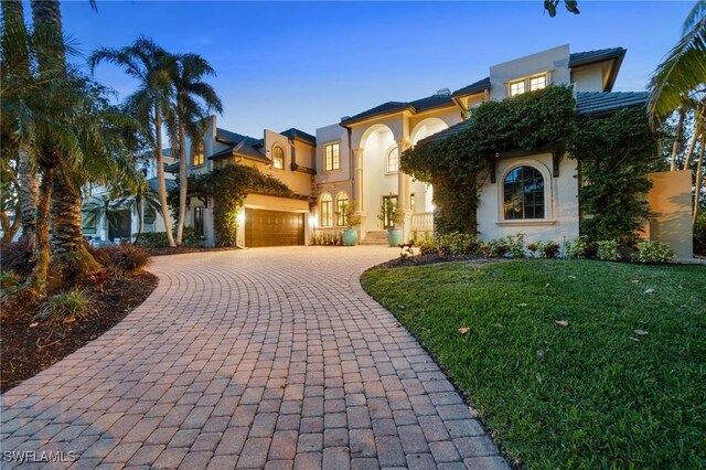 view of front of house featuring a front yard, decorative driveway, and stucco siding