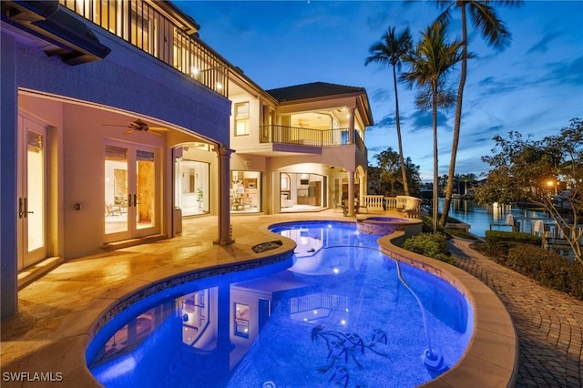 view of pool featuring a pool with connected hot tub, a patio, a ceiling fan, and french doors