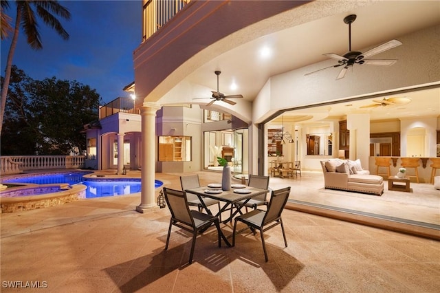 view of patio featuring a ceiling fan, outdoor dining space, a pool with connected hot tub, and a balcony