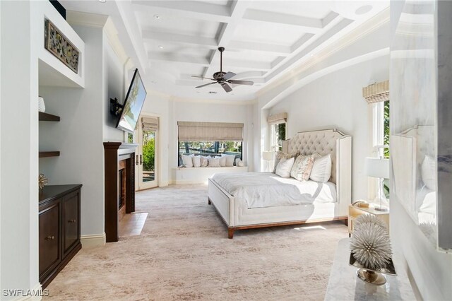 bedroom featuring baseboards, coffered ceiling, a towering ceiling, beam ceiling, and a high end fireplace