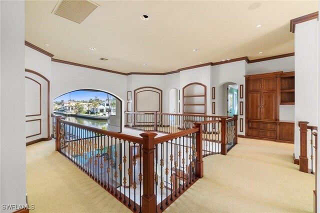 hall with arched walkways, light colored carpet, visible vents, and recessed lighting