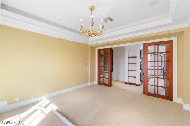 empty room with light carpet, visible vents, a tray ceiling, french doors, and a notable chandelier