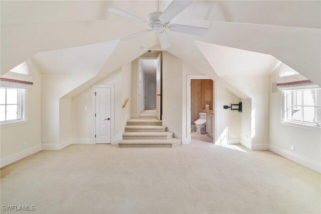 bonus room with carpet floors, ceiling fan, stairs, and lofted ceiling