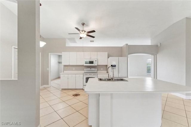 kitchen with white cabinetry, white appliances, sink, and an island with sink