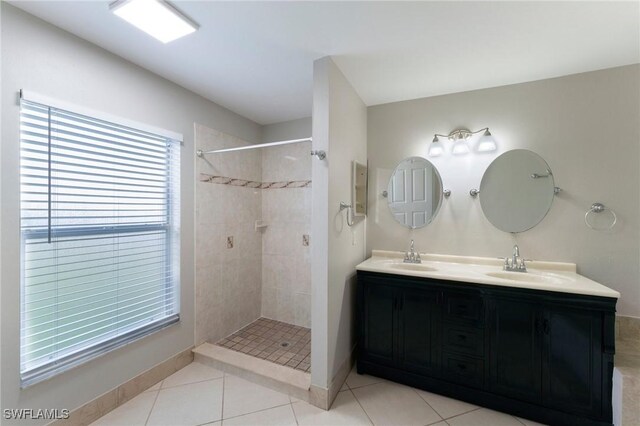 bathroom featuring tile patterned flooring, vanity, and tiled shower