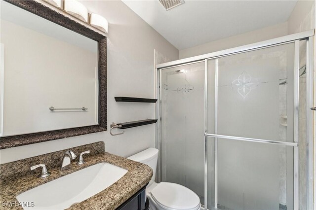 bathroom with vanity, toilet, and walk in shower