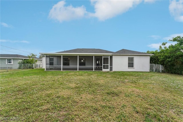 back of property featuring a sunroom and a lawn