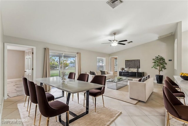 dining space featuring ceiling fan, lofted ceiling, and light tile patterned floors