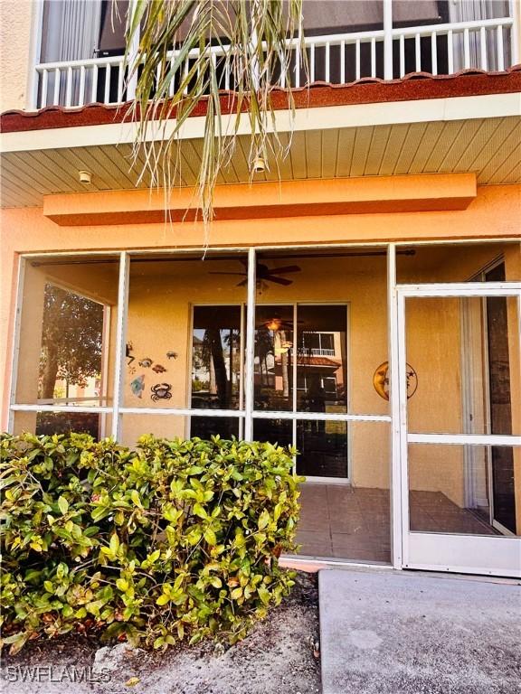 property entrance with a balcony and stucco siding