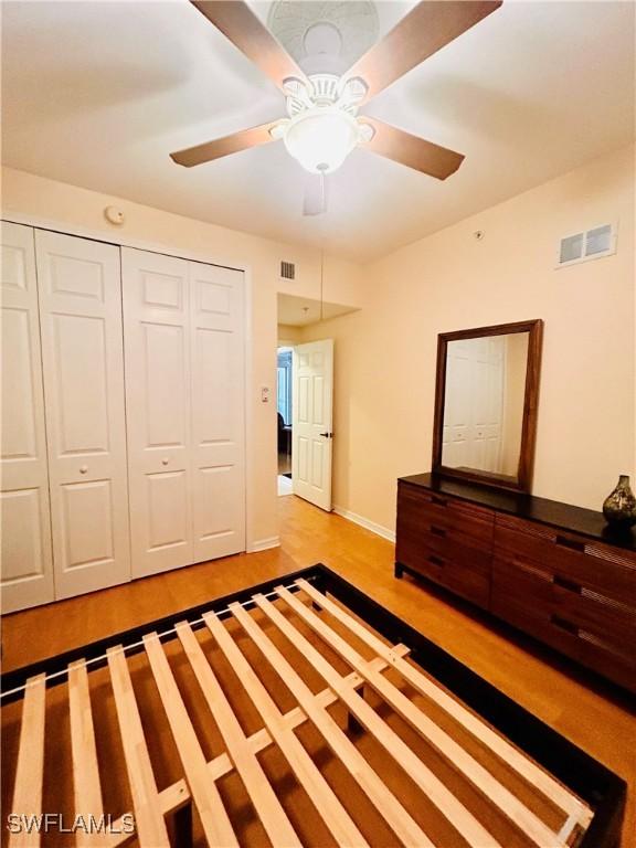 unfurnished bedroom featuring light hardwood / wood-style flooring, a closet, and ceiling fan