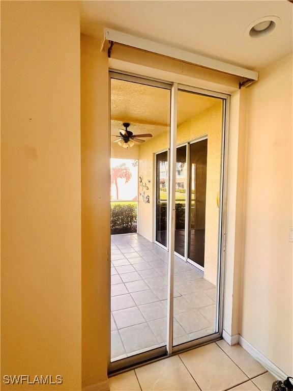 entryway with tile patterned floors and ceiling fan