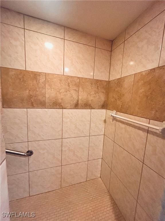 interior details featuring a tile shower