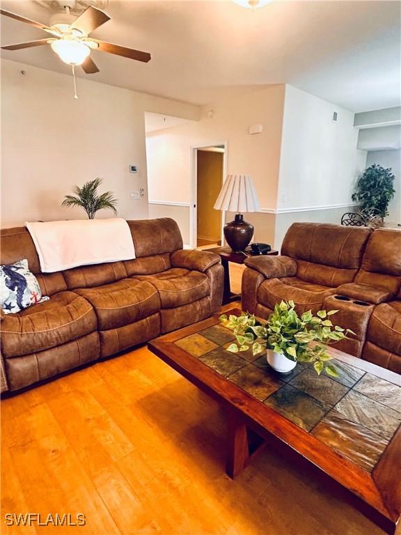 living room featuring ceiling fan and hardwood / wood-style floors