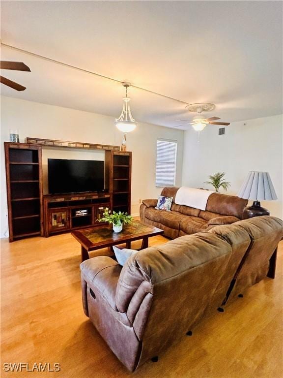 living room with light wood-type flooring and ceiling fan