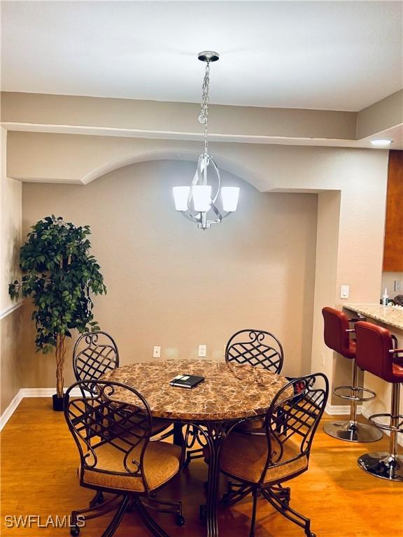 dining room with hardwood / wood-style flooring and a chandelier