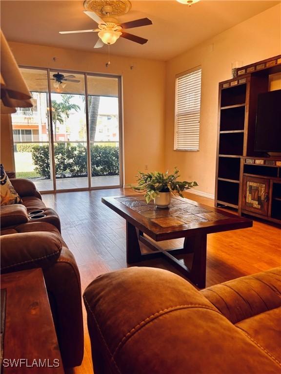 living room with hardwood / wood-style flooring and ceiling fan