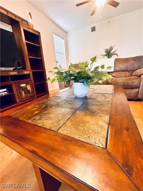 unfurnished living room featuring visible vents and ceiling fan