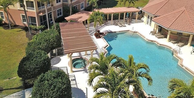 view of swimming pool with a hot tub, a pergola, and a patio