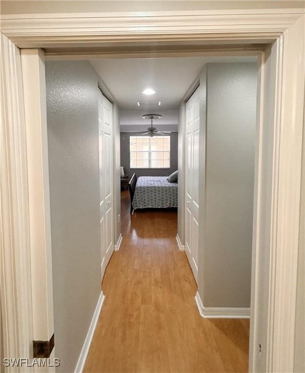 hallway with baseboards and light wood finished floors