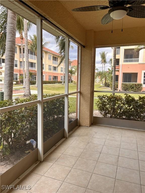 unfurnished sunroom featuring ceiling fan