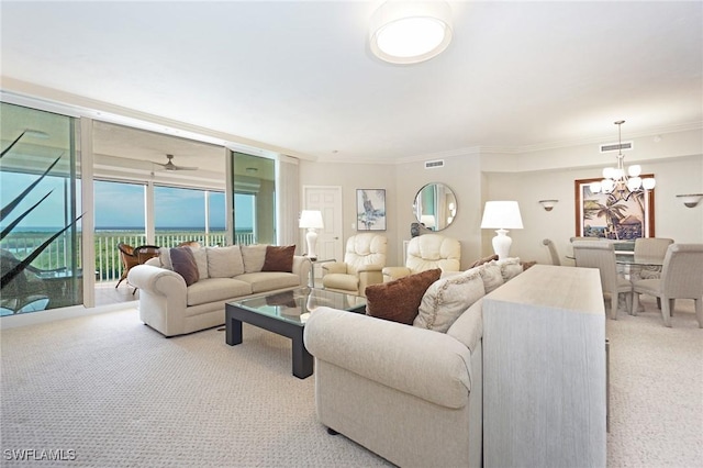 carpeted living room with a notable chandelier, crown molding, and floor to ceiling windows