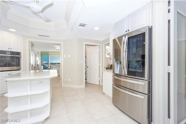 kitchen with light tile patterned flooring, white cabinetry, crown molding, a center island, and stainless steel appliances