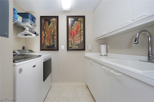 laundry room featuring cabinets, separate washer and dryer, sink, and light tile patterned floors