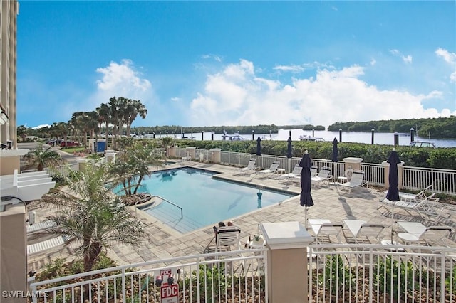 view of pool with a patio and a water view