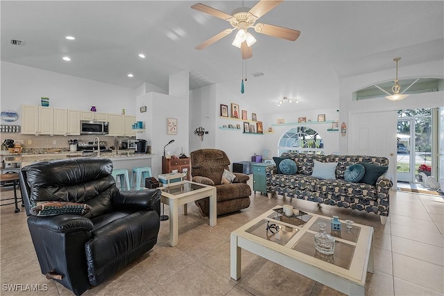 tiled living room with ceiling fan, sink, and high vaulted ceiling