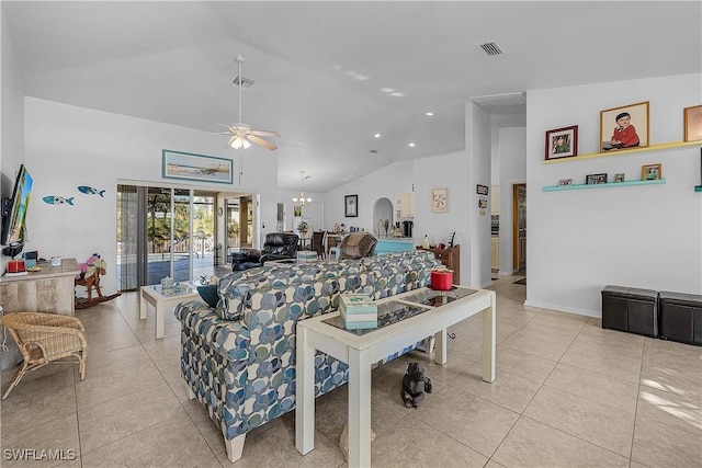 tiled living room with ceiling fan with notable chandelier and high vaulted ceiling