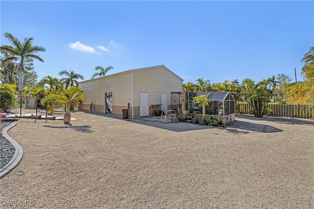 rear view of property featuring glass enclosure
