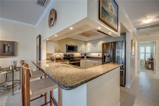 kitchen with crown molding, stainless steel appliances, a breakfast bar, and kitchen peninsula