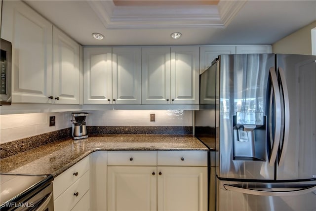 kitchen with a raised ceiling, stainless steel refrigerator with ice dispenser, ornamental molding, and white cabinets