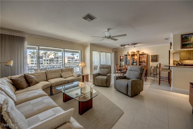 tiled living room featuring crown molding and ceiling fan