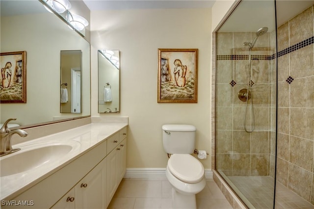 bathroom featuring tile patterned flooring, vanity, tiled shower, and toilet