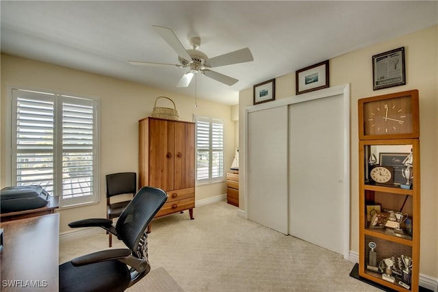 carpeted office with plenty of natural light and ceiling fan