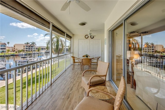 balcony featuring a water view and ceiling fan