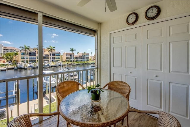 balcony with ceiling fan and a water view